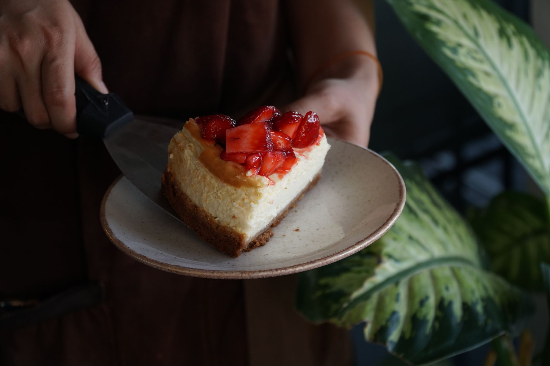 Ein Stück Käsekuchen mit Erdbeeren auf einem Keramikteller